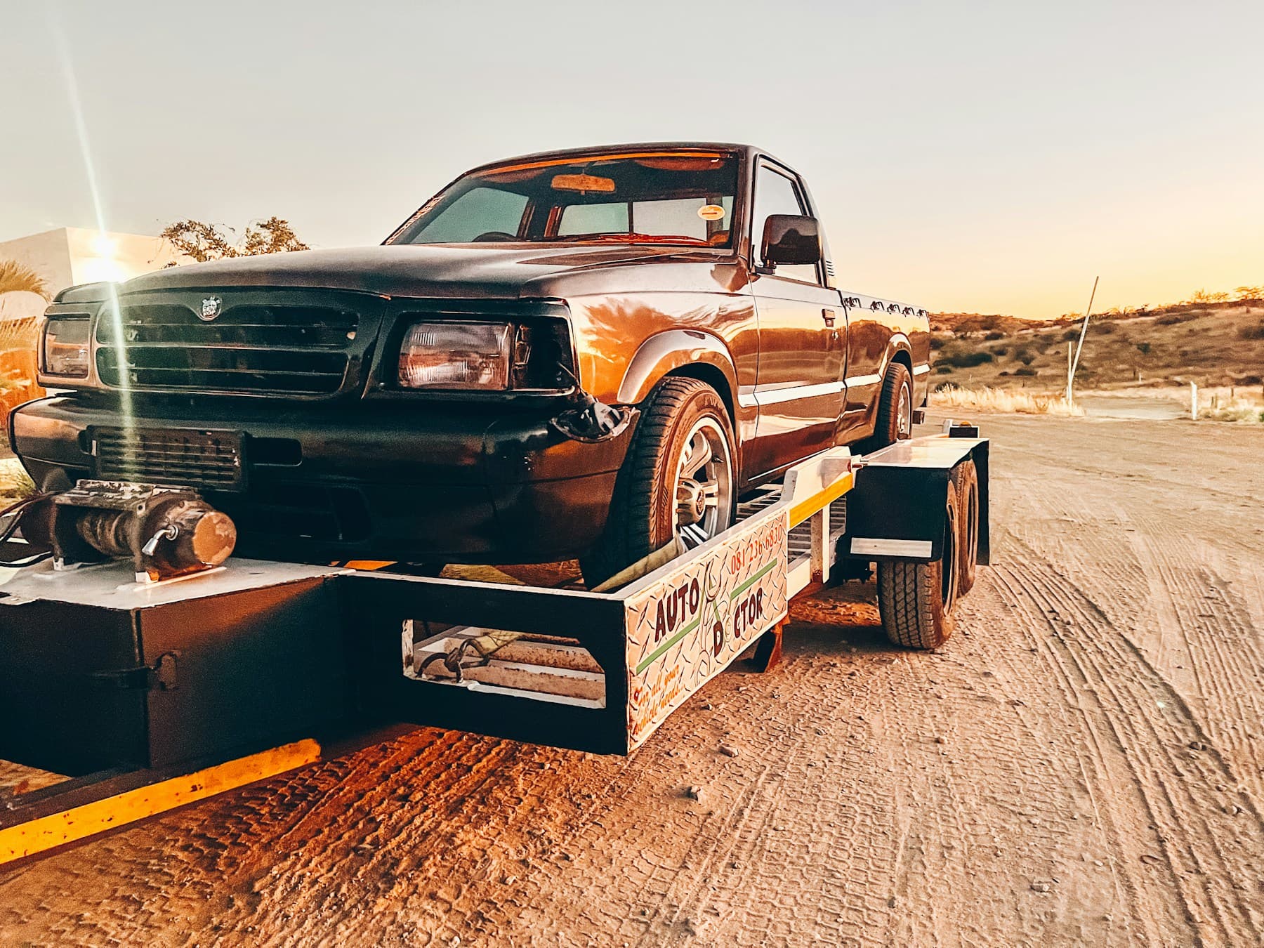 Truck strapped onto a tandem-axle car hauler trailer