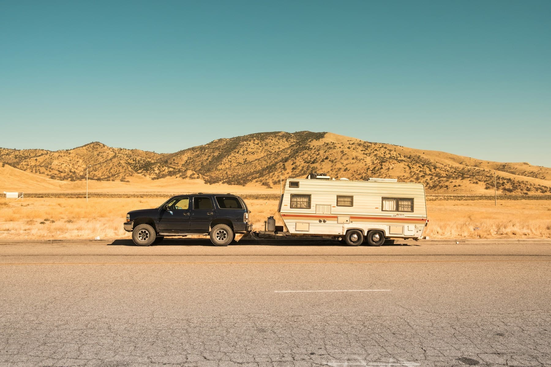 SUV towing a travel trailer across the Arizona desert